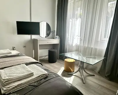 a bedroom with a bed and a glass table at Sofy apartman in Niš