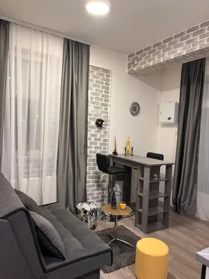 a living room with a couch and a piano at Sofy apartman in Niš