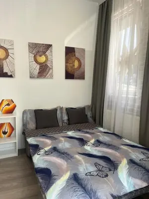 a bedroom with a bed with a colorful blanket at Sofy apartman in Niš