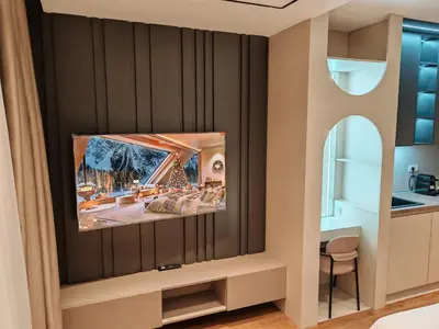 a living room with a tv on a wall at Planet Lux Apartment with secured parking In the garage in Niš