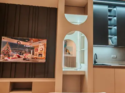 a kitchen with a tv hanging on a wall at Planet Lux Apartment with secured parking In the garage in Niš