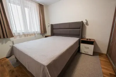 a small bedroom with a bed and a window at Apartmani Jovičić Kopaonik in Kopaonik