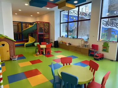 a room with a play area with a table and chairs at Apartmani Jovičić Kopaonik in Kopaonik