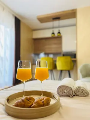 two glasses of orange juice and pastries on a table at GOLDEN SS Studio in Vrnjačka Banja