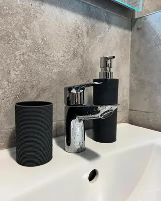 a bathroom sink with a faucet and two cups at GOLDEN SS Studio in Vrnjačka Banja
