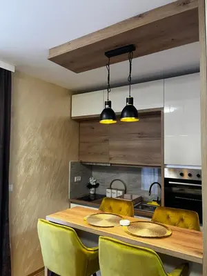 a kitchen with a wooden table and yellow chairs at GOLDEN SS Studio in Vrnjačka Banja