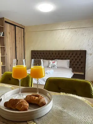 a table with two glasses of orange juice and croissants at GOLDEN SS Studio in Vrnjačka Banja