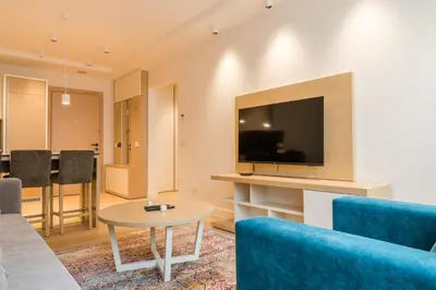 a living room with a couch and a tv and a table at Apartman Mimi Zepterme Vrnjačka Banja in Vrnjačka Banja