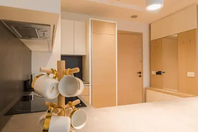 a kitchen with mugs hanging on a rack at Apartman Mimi Zepterme Vrnjačka Banja in Vrnjačka Banja