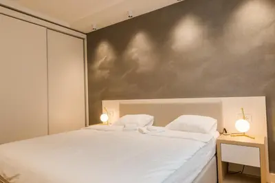 a bedroom with a large white bed with two lamps at Apartman Mimi Zepterme Vrnjačka Banja in Vrnjačka Banja