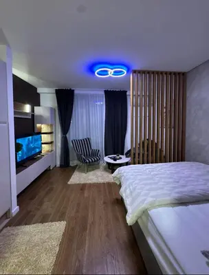 a bedroom with a large bed and a blue light at Delta SPA Residence in Niš
