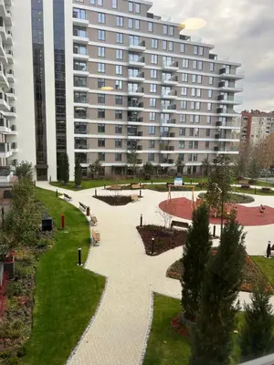 a park with a large building in the background at Delta SPA Residence in Niš