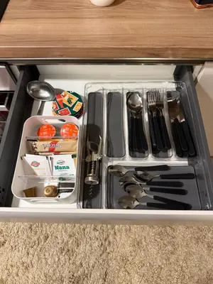 a drawer in a cabinet filled with utensils at Delta SPA Residence in Niš