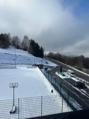 a tennis court covered in snow next to a highway at Vidik Residence A23 in Kopaonik