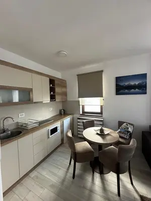 a kitchen with a table and chairs in a room at Vidik Residence A23 in Kopaonik