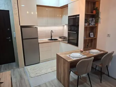a kitchen with a table and chairs and a sink at Apartmani Marjanovic in Jagodina