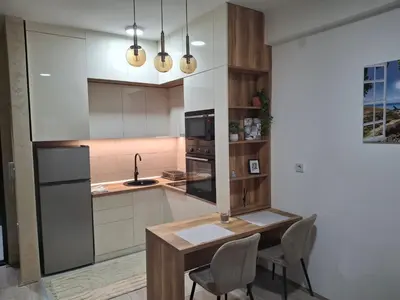 a kitchen with a table and chairs and a sink at Apartmani Marjanovic in Jagodina