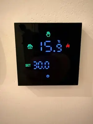 an electronic clock on a wall with blue and green clocks at Woodland B65 Residence Hill Kopaonik in Kopaonik