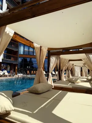 a row of beds next to a swimming pool at Woodland B65 Residence Hill Kopaonik in Kopaonik