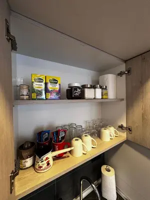 a kitchen shelf with cups and other items on it at Woodland B65 Residence Hill Kopaonik in Kopaonik