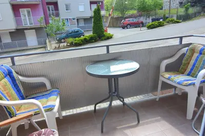 a table and two chairs on a balcony at Apartman Nidža in Vrnjačka Banja