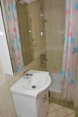 a bathroom with a sink and a shower and a tub at Apartman Nidža in Vrnjačka Banja
