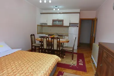a kitchen and dining room with a table and a bed at Apartman Nidža in Vrnjačka Banja