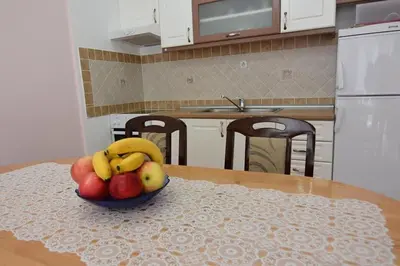 a bowl of fruit on a table in a kitchen at Apartman Nidža in Vrnjačka Banja