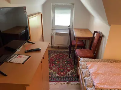 a small room with a desk and a table and a table and chair at Slobo Velickovic in Prokuplje