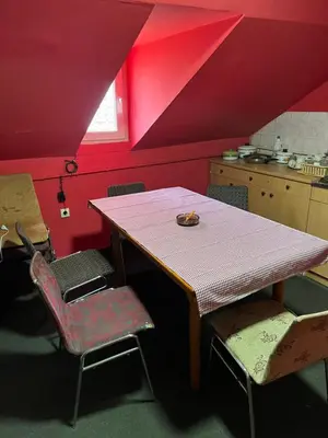 a table and chairs in a kitchen with red walls at Slobo Velickovic in Prokuplje