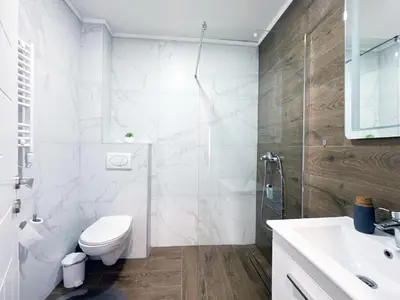 a white bathroom with a toilet and a sink at Moj Mir in Vrnjačka Banja