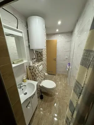 a bathroom with a sink and a toilet and a mirror at Apartman Anastasija in Kuršumlija