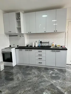 a large white kitchen with white cabinets and appliances at Apartman Anastasija in Kuršumlija