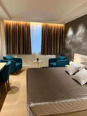 a bedroom with a large bed and blue chairs at Zepterme 509 in Vrnjačka Banja