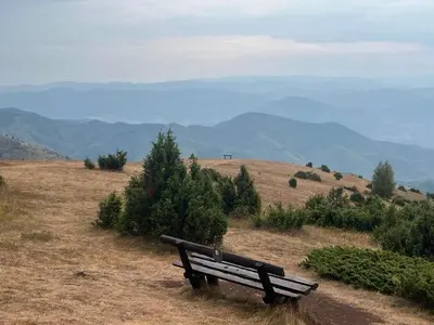 a bench sitting on a hill with mountains in the background at Kraljevi Čardaci apartman Lux 10 in Kopaonik