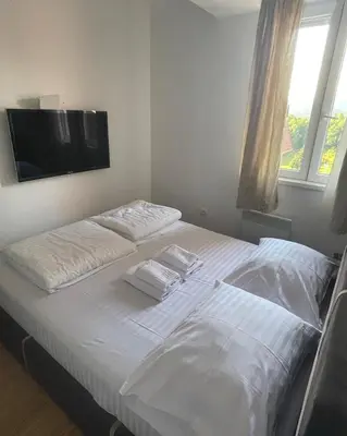 a bedroom with two beds and a flat screen tv at Kraljevi Čardaci apartman Lux 10 in Kopaonik