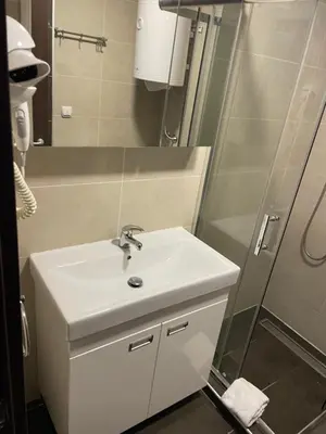 a bathroom with a white sink and a shower at Kraljevi Čardaci apartman Lux 10 in Kopaonik