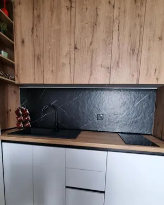 a kitchen with a black counter top and wooden cabinets at The View A74 in Raška