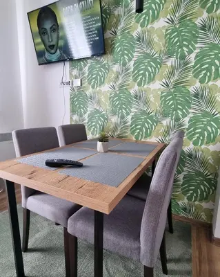 a wooden table with two chairs and a wall at The View A74 in Raška