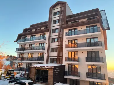 a tall white building with snow on the ground at The View A74 in Raška