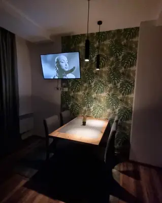a dining room with a table and a tv on a wall at The View A74 in Raška