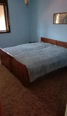 a large bed in a bedroom with a blue wall at Milutovac in Trstenik