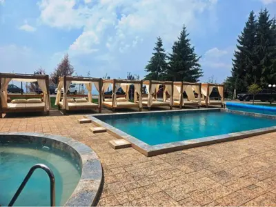 a swimming pool with chairs and a large swimming pool at Bella vista KOP in Kopaonik