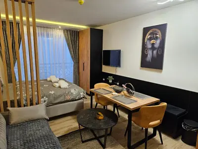 a room with a bed and a table and a dining room at Bella vista KOP in Kopaonik