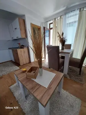a living room with a table and a dining room at Kovacevic Apartmani in Raška