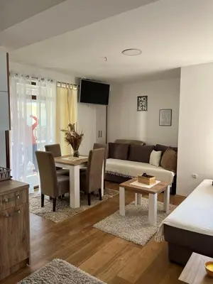a living room with a couch and a table at Kovacevic Apartmani in Raška