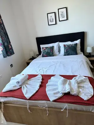 a bedroom with a bed with towels on it at Milmari Apartman Kopaonik in Kopaonik