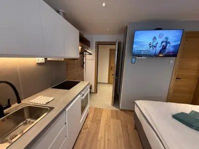 a kitchen with a sink and a tv on the wall at Juli Kop in Kopaonik