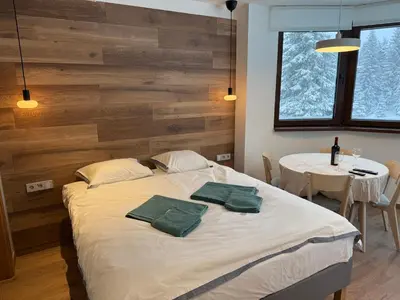 a bedroom with a bed with two green towels on it at Juli Kop in Kopaonik