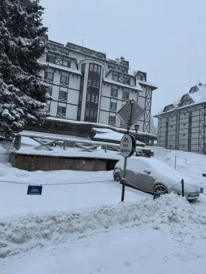 a car covered in snow in front of a building at Juli Kop in Kopaonik